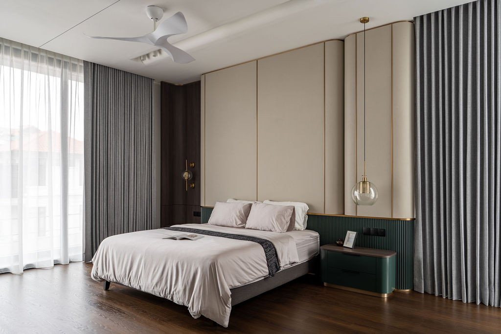 The master suite layers deep oak flooring with greige fabric panels and emerald ribbed detailing with bronze inlays to define a calm environment