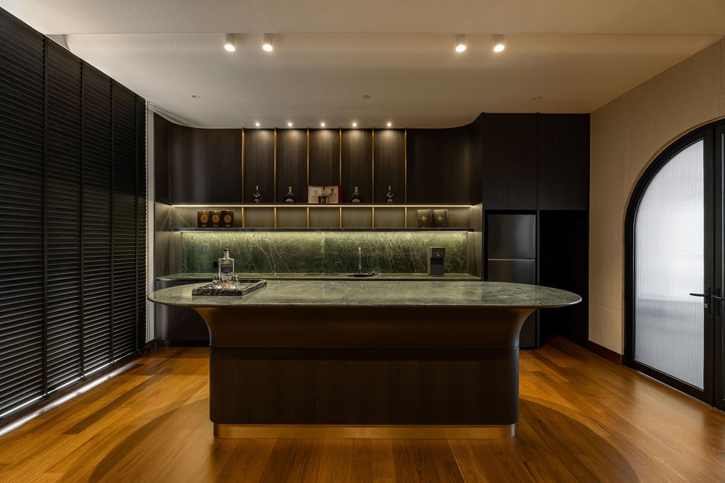 The entertainment room features a green-veined marble island with a sculptural base, encouraging fluid movement