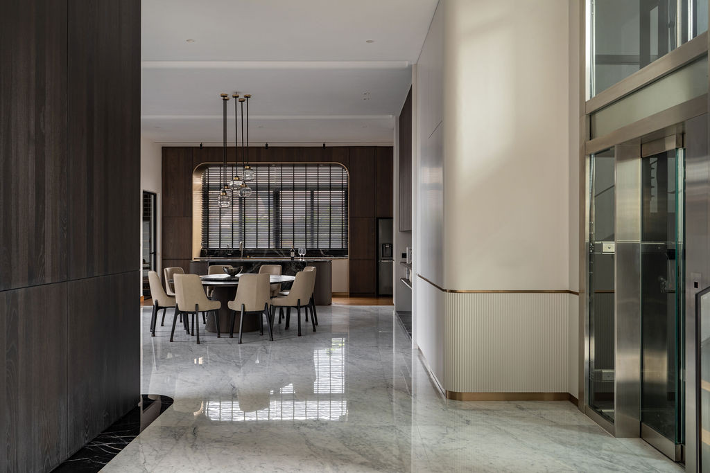 The entrance foyer features polished marble flooring and ribbed timber detailing that extends sight lines through to the dining area