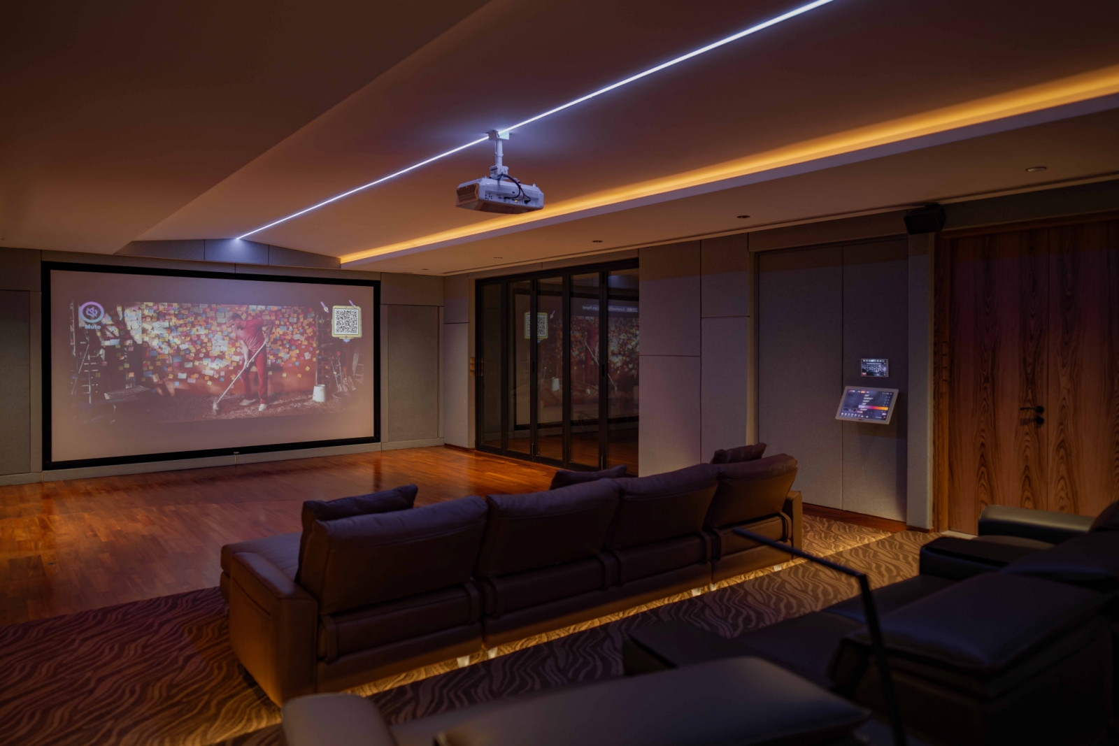 The entertainment room is conceived as a cocooned retreat, where subdued lighting, acoustic treatments and warm timber tones create a hushed atmosphere