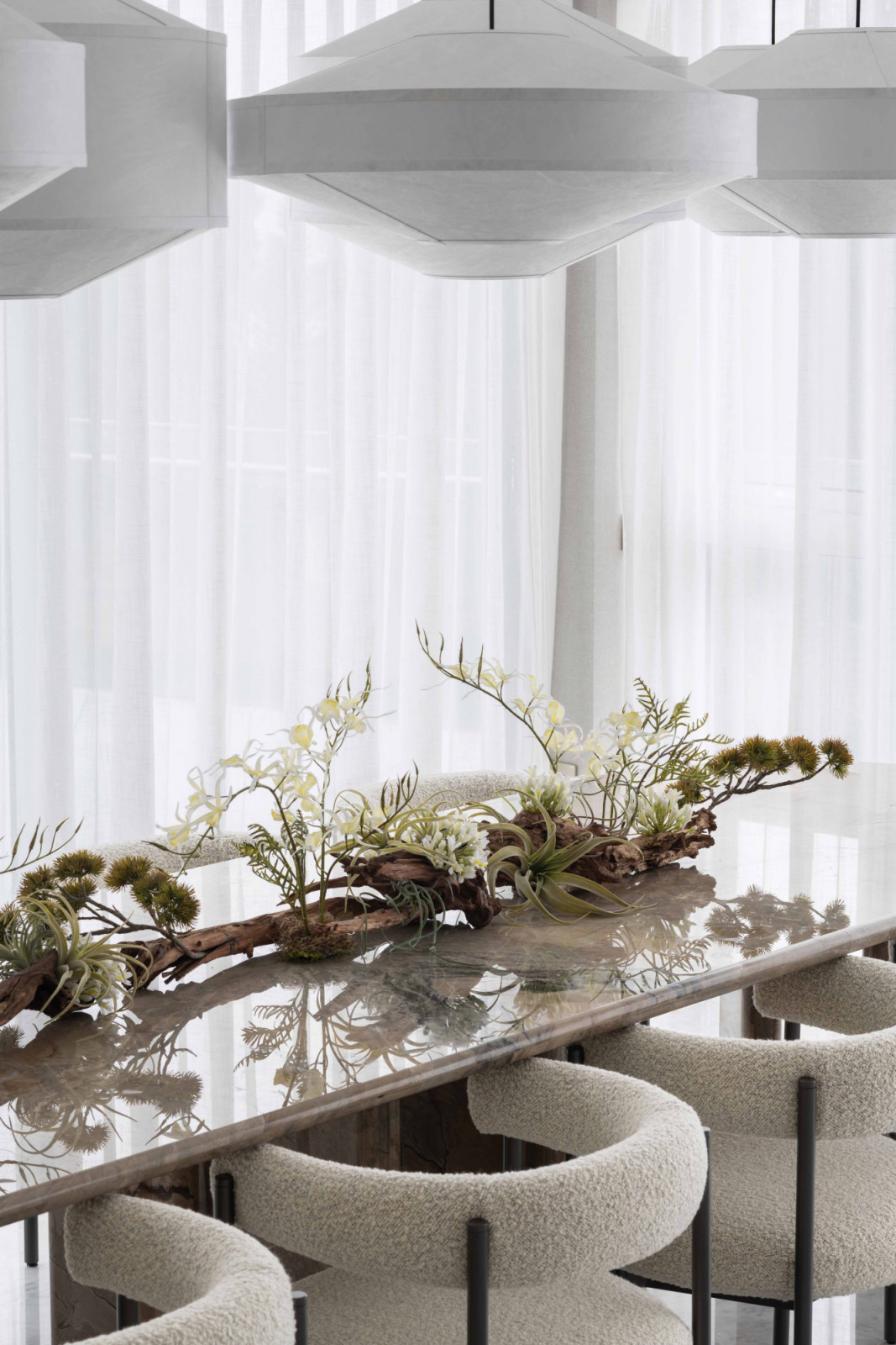 A series of Kite suspension lamps from New Works floats above the dining tab