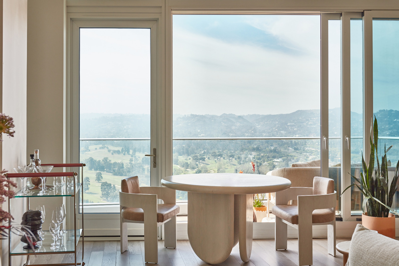 The dining room and outdoor terrace of a young beauty entrepreneur's apartment in Los Angeles, designed by The Scale Collective