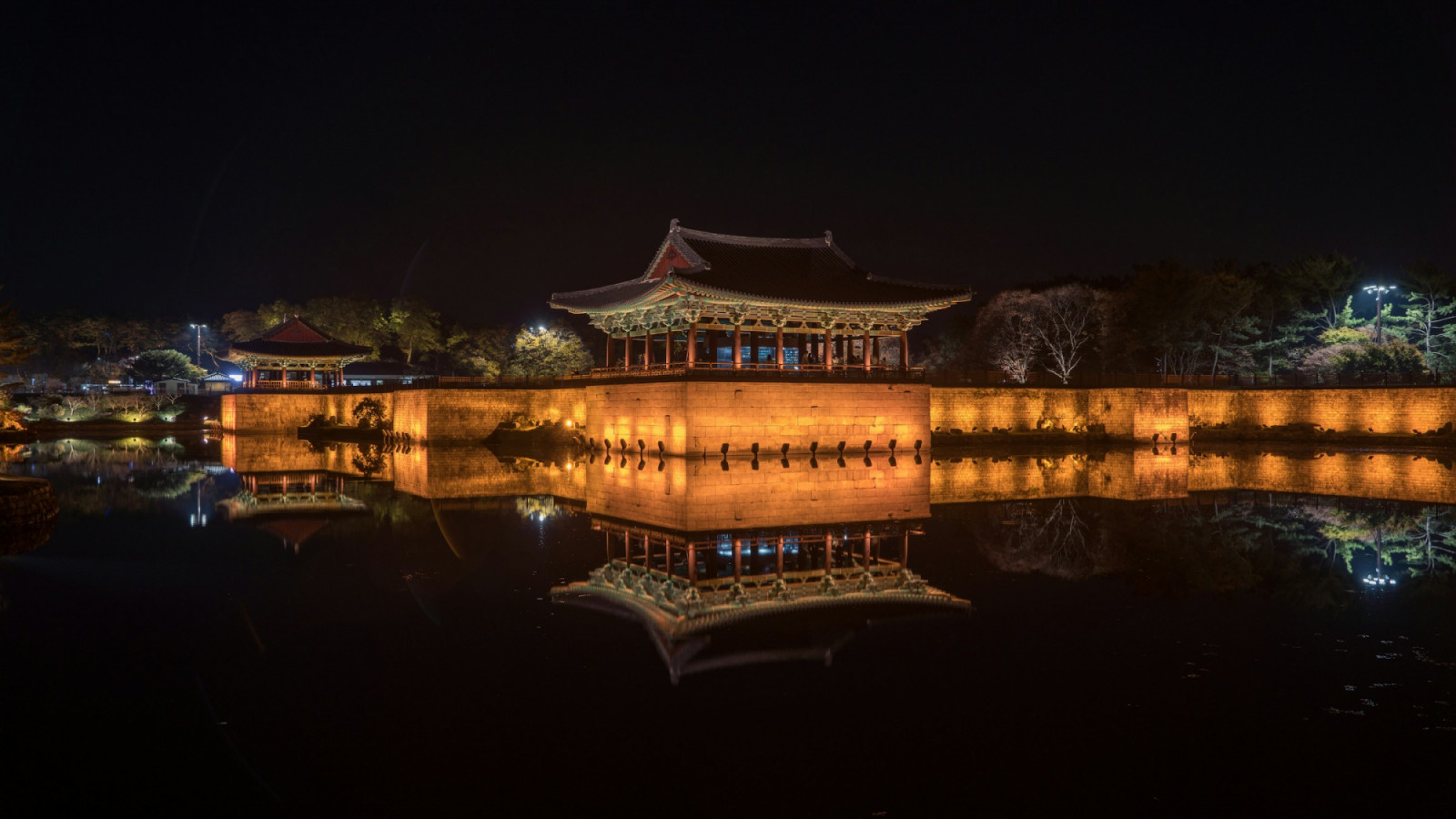 An illuminated palace complex and reflective pond used as a backdrop for courtly scenes in historical K-dramas (Photo: John Ko/Unsplash)