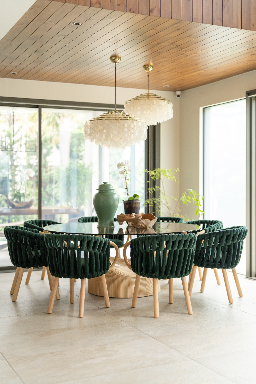 The dining room chairs in Pia Wurtzbach Jauncey's home echo the overarching use of emerald tones as a neutral, as a celadon ginger jar on top of the glass dining table reiterates the use of the colour