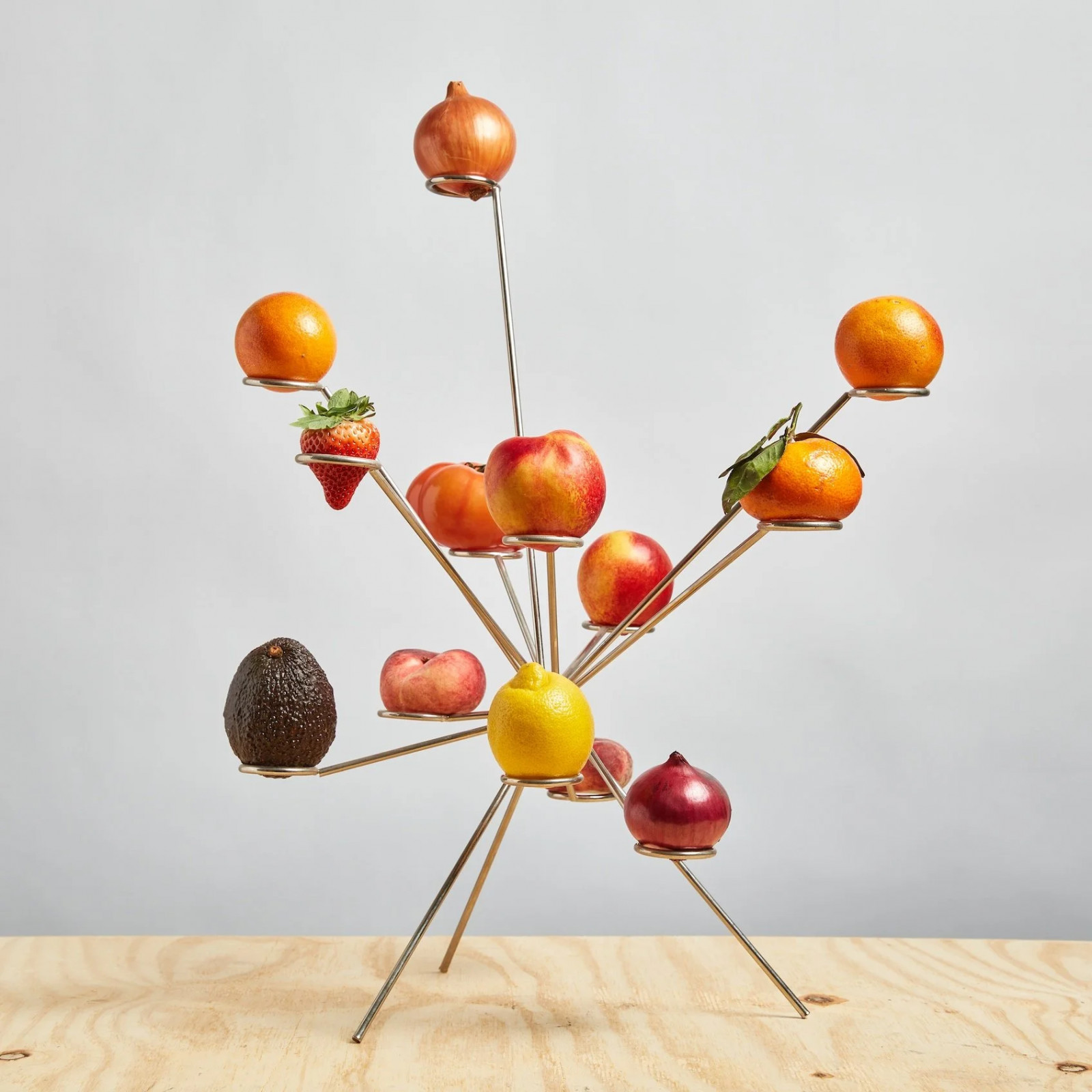 The sculptural fruit bowl elevates citrus and other produce on individual brass arms radiating from a central base