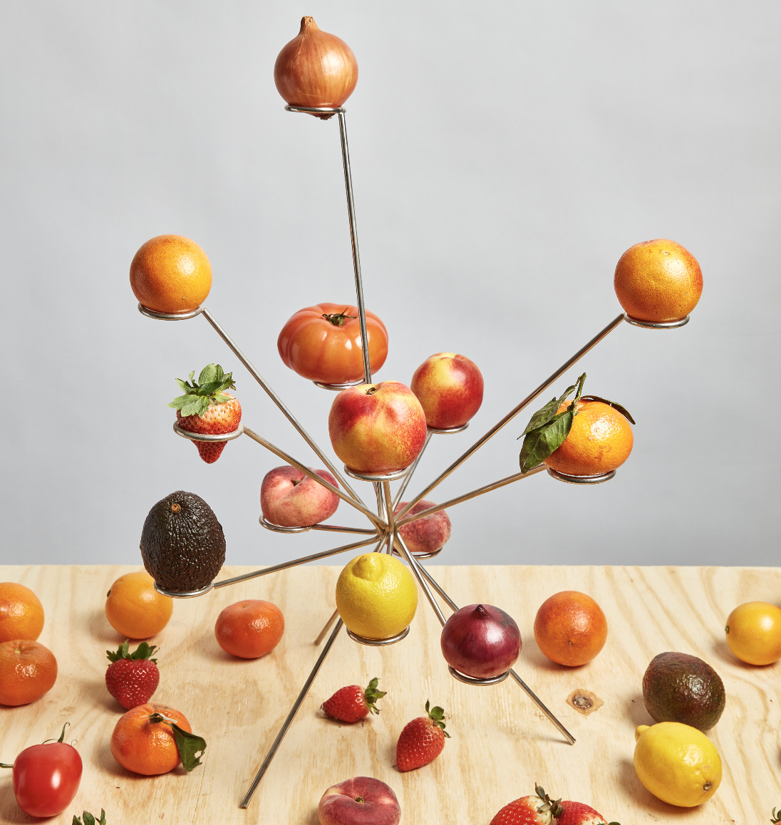 The Exploded Fruit Bowl displays multiple varieties of fruit across its sculptural frame, transforming produce into a tabletop composition