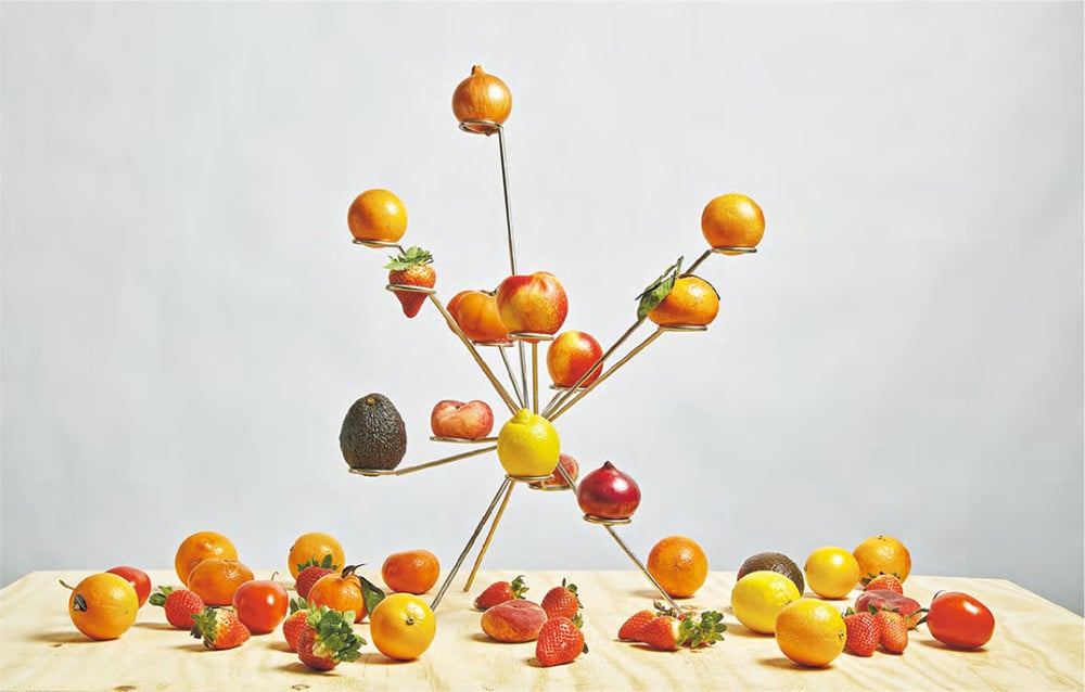 British designer Paul Cocksedge’s Exploded Fruit Bowl features radiating brass-toned metal arms, each holding individual fruits on small platforms
