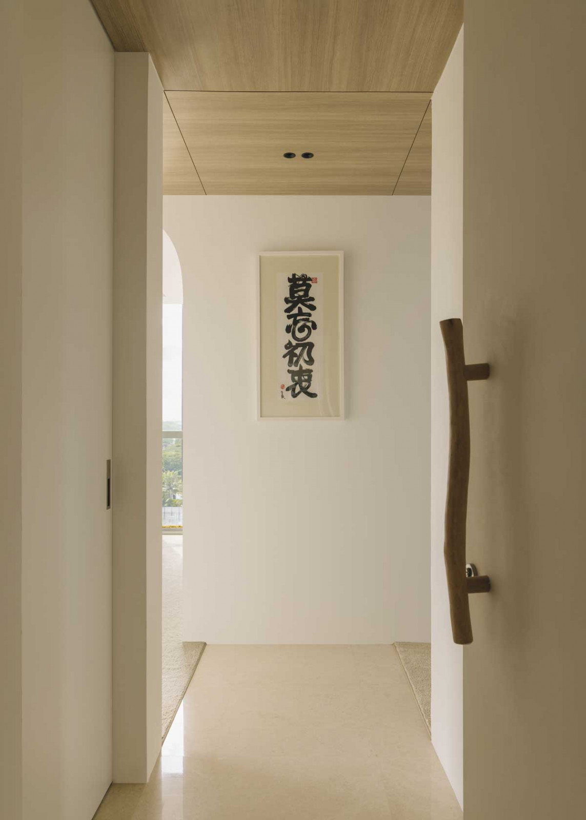 The organic door handle and accompanying calligraphy evoke a poetic mood in this East Coast Apartment
