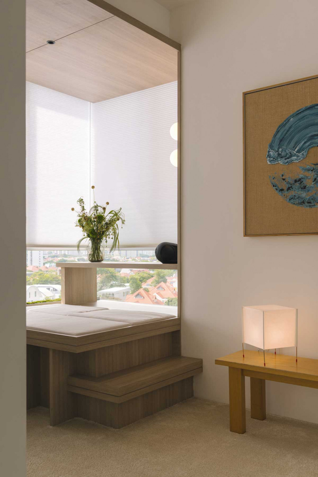 A corner cleverly transformed into an elevated Japanese-style sitting area, while plush carpeting and whitewashed walls make the artwork stand out