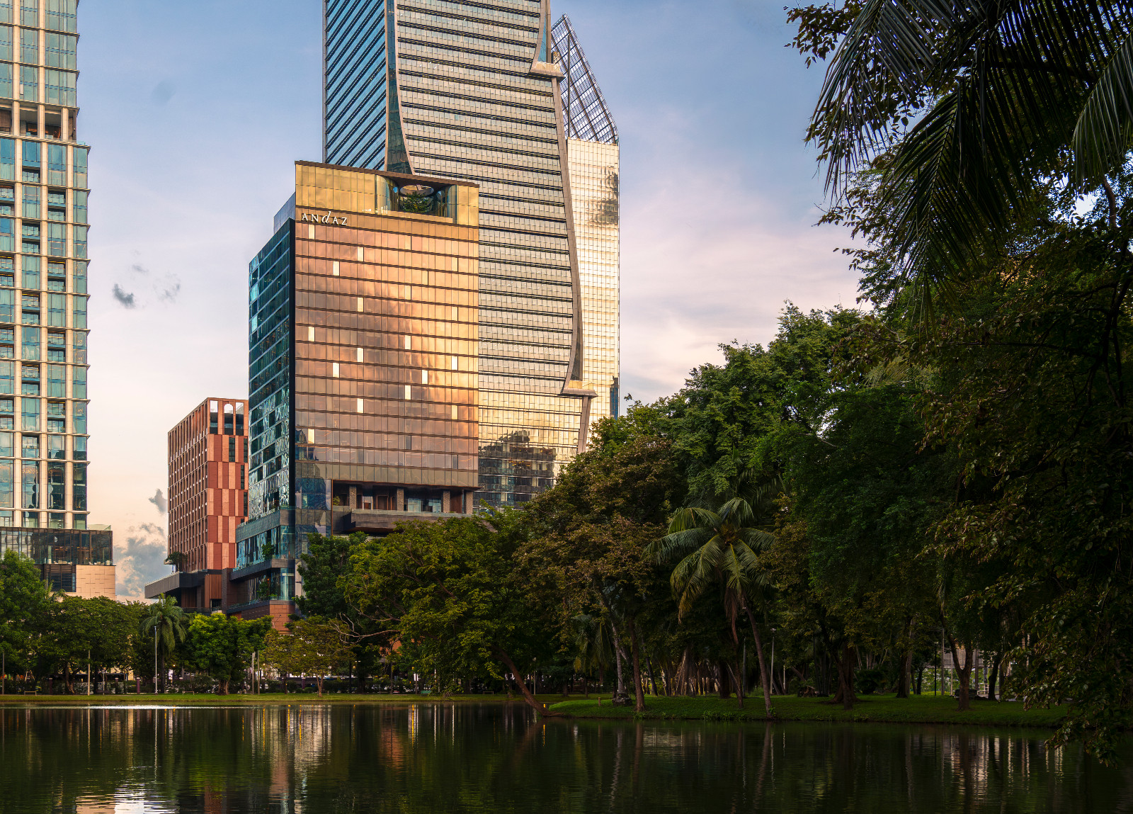โรงแรม Andaz One Bangkok ในยามพระอาทิตย์ตก เมื่อแสงสีทองอาบไล้เส้นสายสถาปัตยกรรมร่วมสมัย ตัดกับความเขียวขจีของสวนลุมพินี (ภาพ: Andaz One Bangkok)