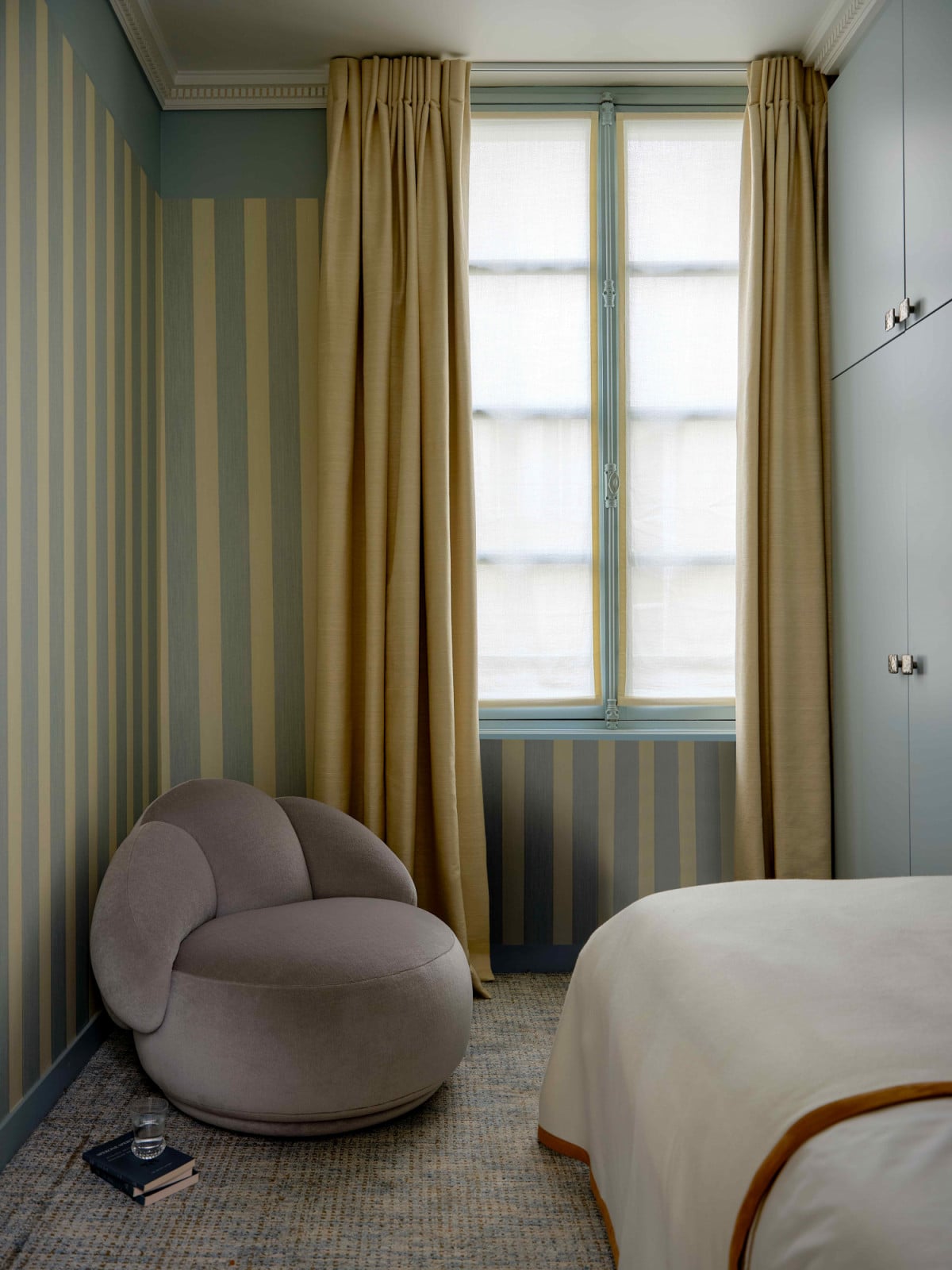 The whimsical striped walls and the cosy Georgia sofa for reading by the window