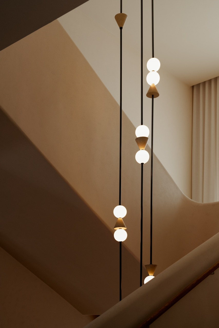 Custom pendant lighting detail in the stairwell, part of the layered lighting strategy Lim describes as creating ‘visual rhythm while casting a warm, diffused glow.’