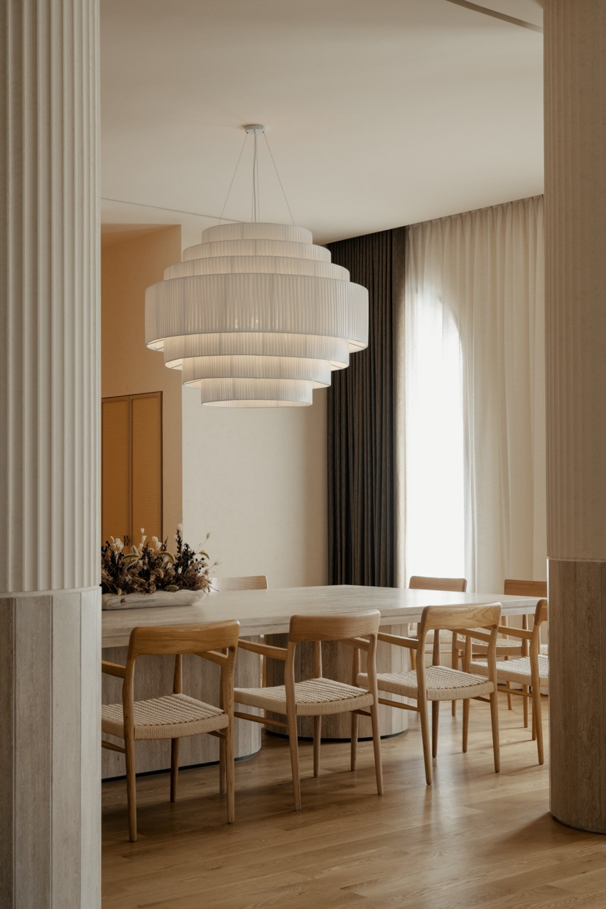 Dining area with custom pendant light from Big Brain and Joot dining chairs by Nic Chris, featuring arched windows that frame tropical views