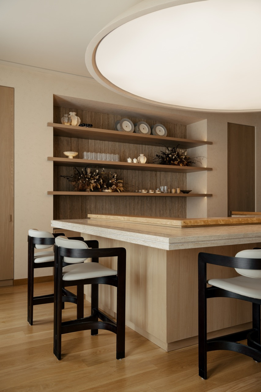 The private omakase bar with curved ceiling detail and fluted columns exemplifies the Mediterranean-inspired architectural forms