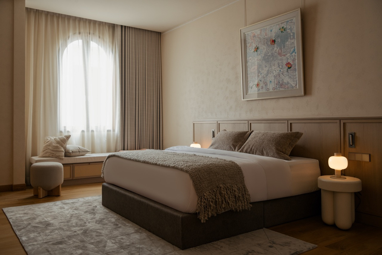 Guest bedroom with arched window seat and artwork, part of the clubhouse’s well-appointed guest suites
