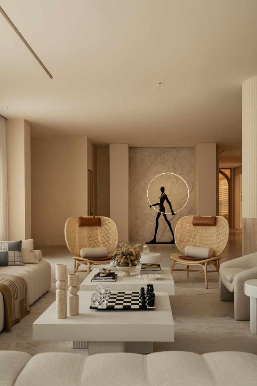 Seating area with caned armchairs and contemporary sculpture, demonstrating the balance between art display and comfortable seating