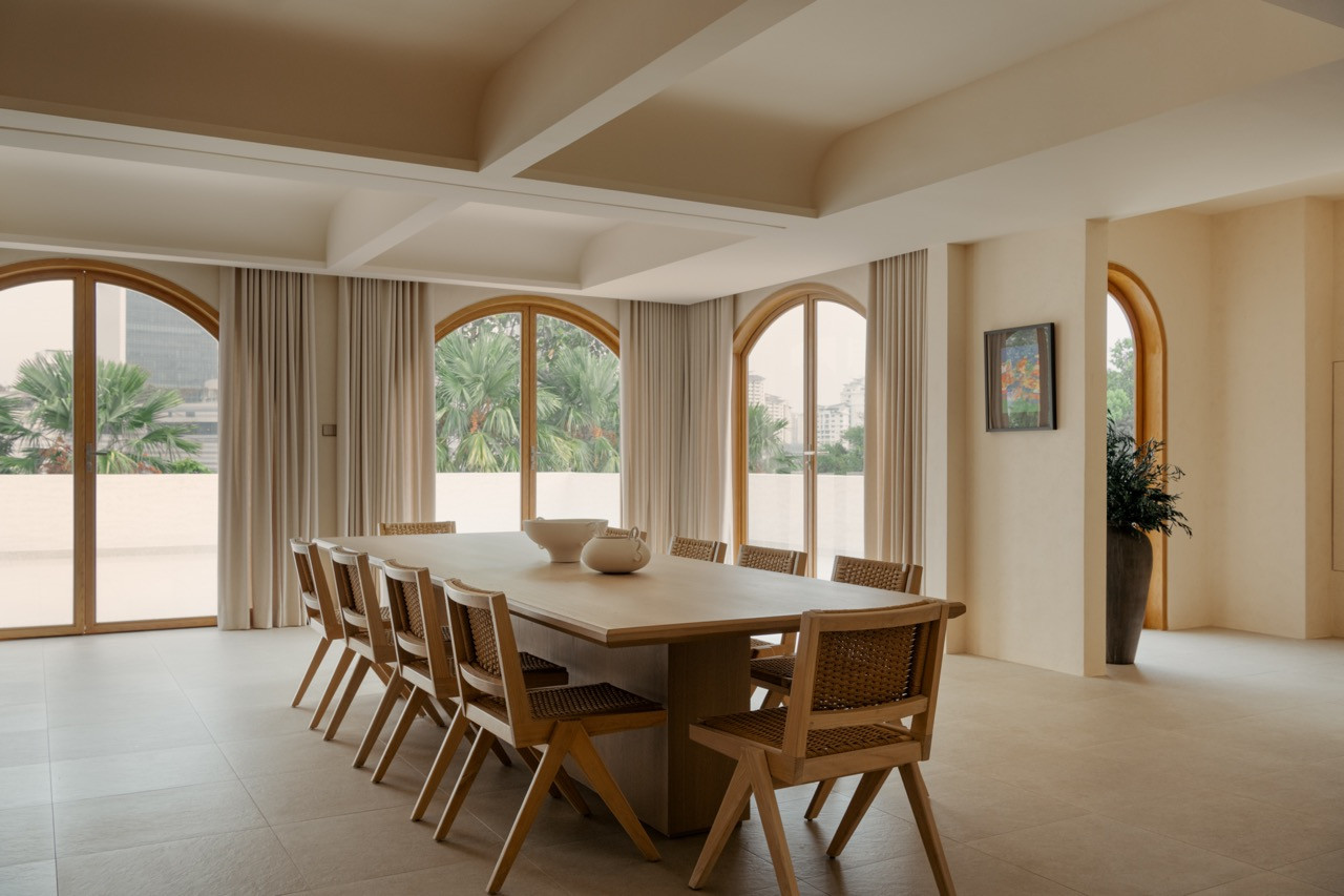 The dining area with arched windows, a custom table, and Joot dining chairs by Nic Chris, exemplifying what Lim calls “quiet monumentality"