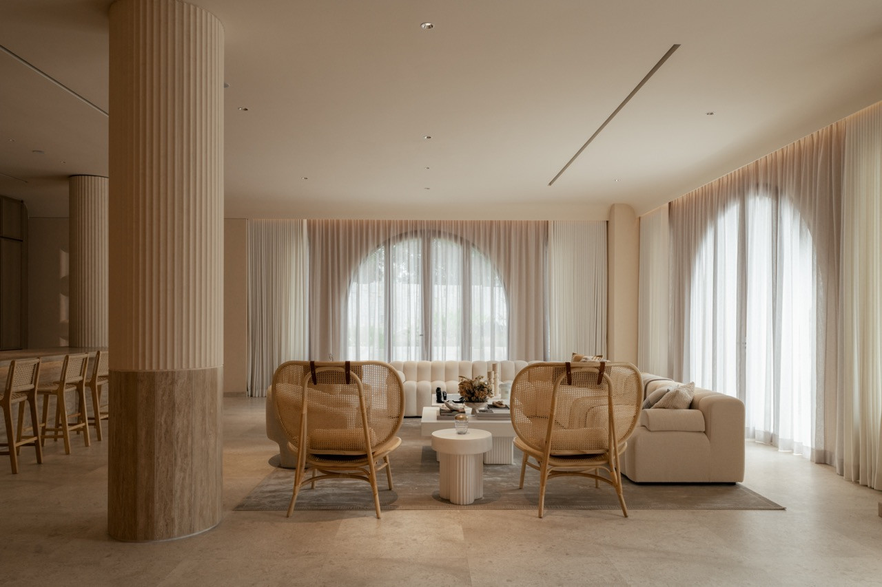 The main living area with caned armchairs and arched windows, showing the open circulation that Lim achieved by ‘reworking internal circulation and proportions to allow the spaces to feel connected and fluid.’