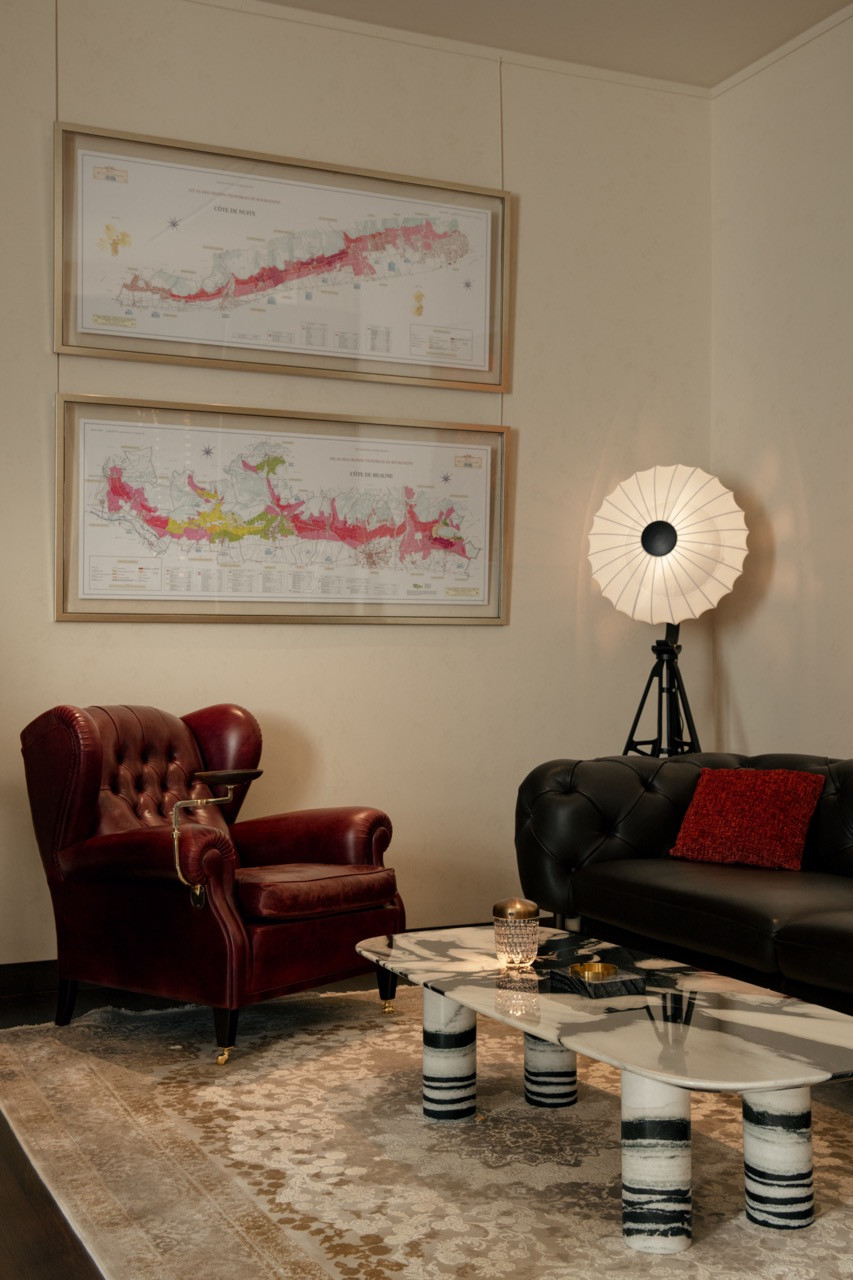 Cigar lounge with vintage maps and classic Chesterfield seating, part of the clubhouse’s curated entertainment spaces.
