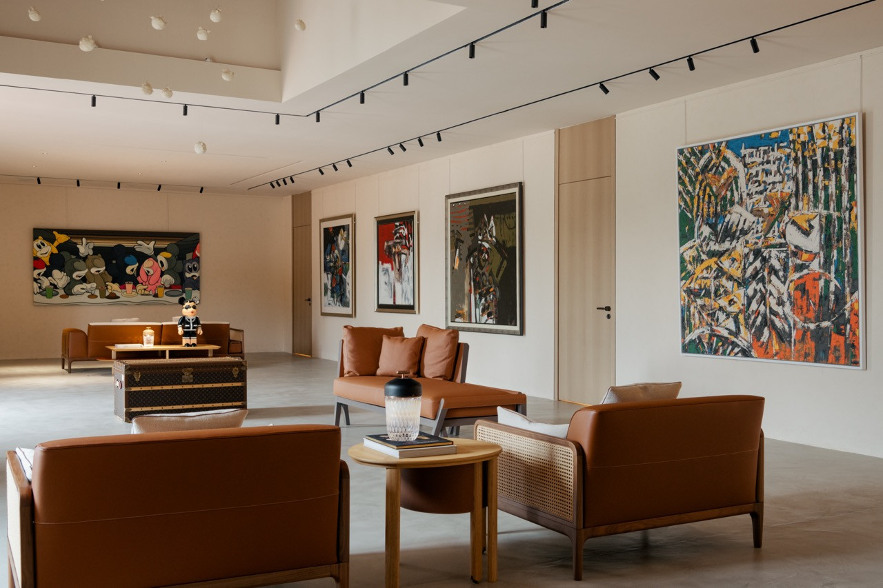 The art gallery space featuring Hermès furniture and multiple works by Awang Damit Ahmad, including ‘Epic Feast’ (2022) and ‘Estetika Timur’ (2001-2003), with a Louis Vuitton Courrier Lozine 110 trunk