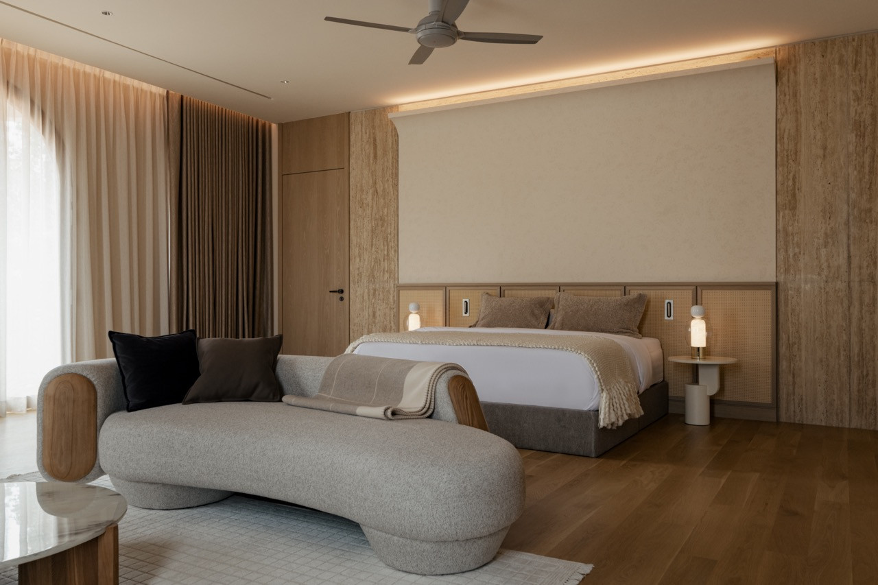 Master bedroom with timber caned headboard and neutral textiles, embodying the project’s restrained earth-toned palette