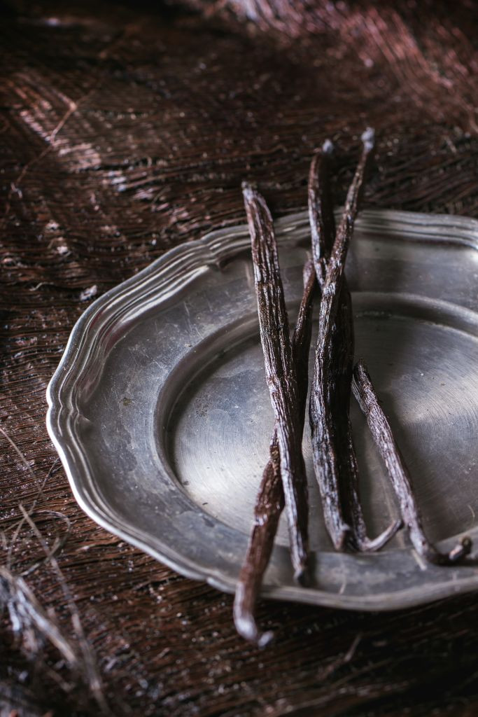 Heap of vanilla sticks in vintage metal plate over dark palm crust. (Photo by: Natasha Breen/REDA/Universal Images Group via Getty Images)