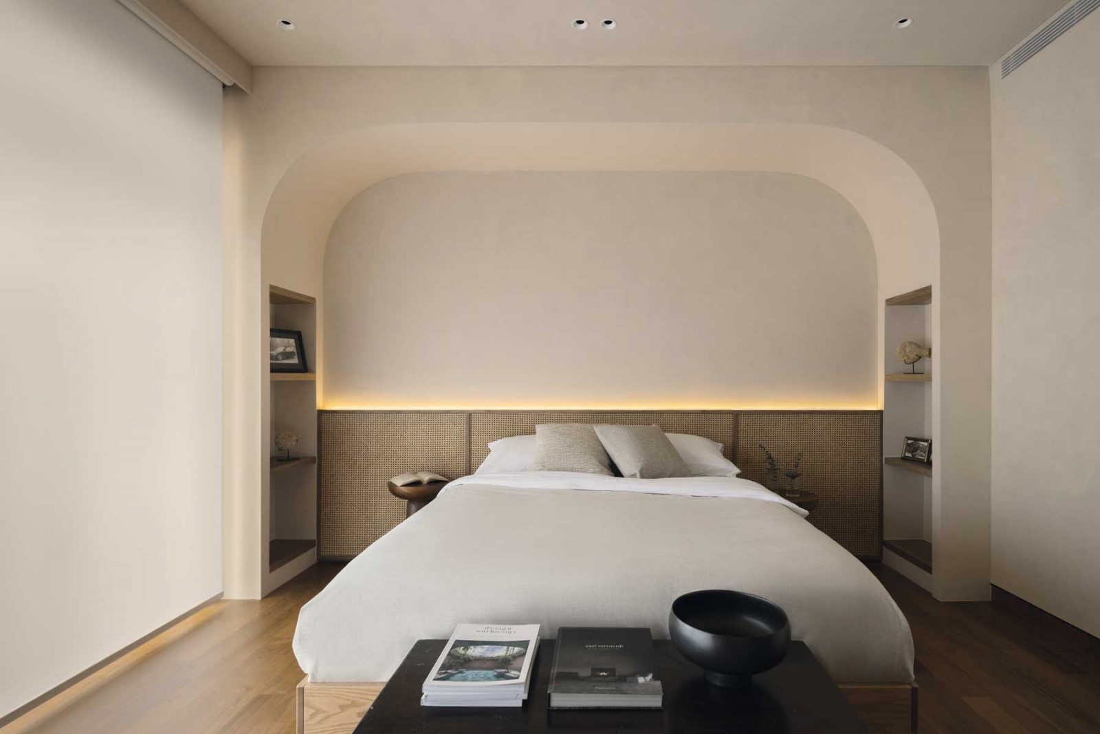 Another bedroom features a bed set within a backlit alcove