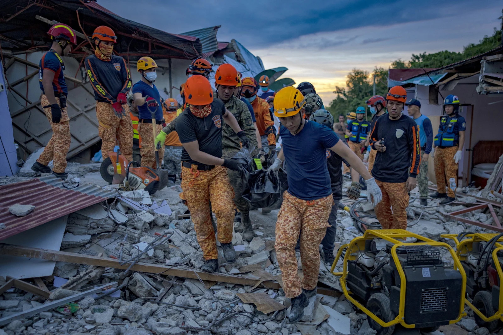Rescue workers carry the body of a resident retrieved from under the rubble of a collapsed building caused by the Cebu earthquake (Photo: Getty Images)