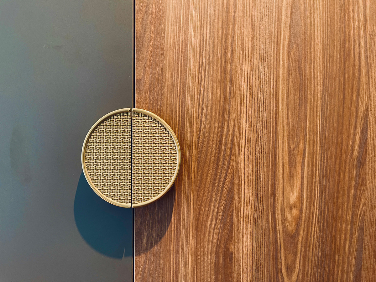 A close-up of a custom door handle highlights the tactile richness of its textured finish
