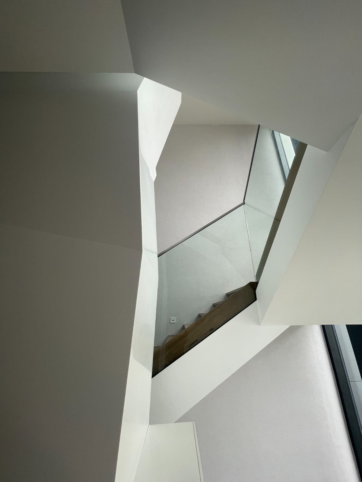 Looking up through the lightwell, daylight filters into the multigenerational home’s interior volumes