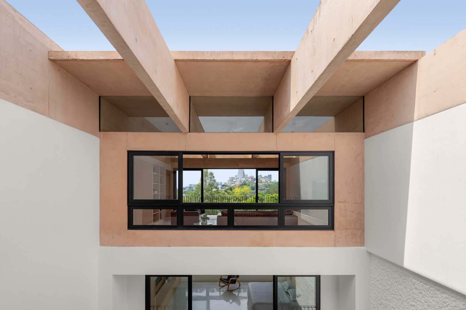 The central courtyard shows how the pink concrete beams of the third floor create deep ceiling coffers