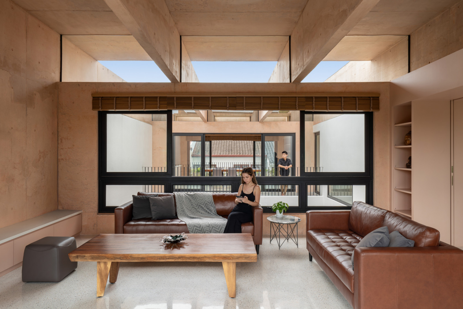 The living room features the exposed column-and-beam expression inspired by ancient structures like Stonehenge