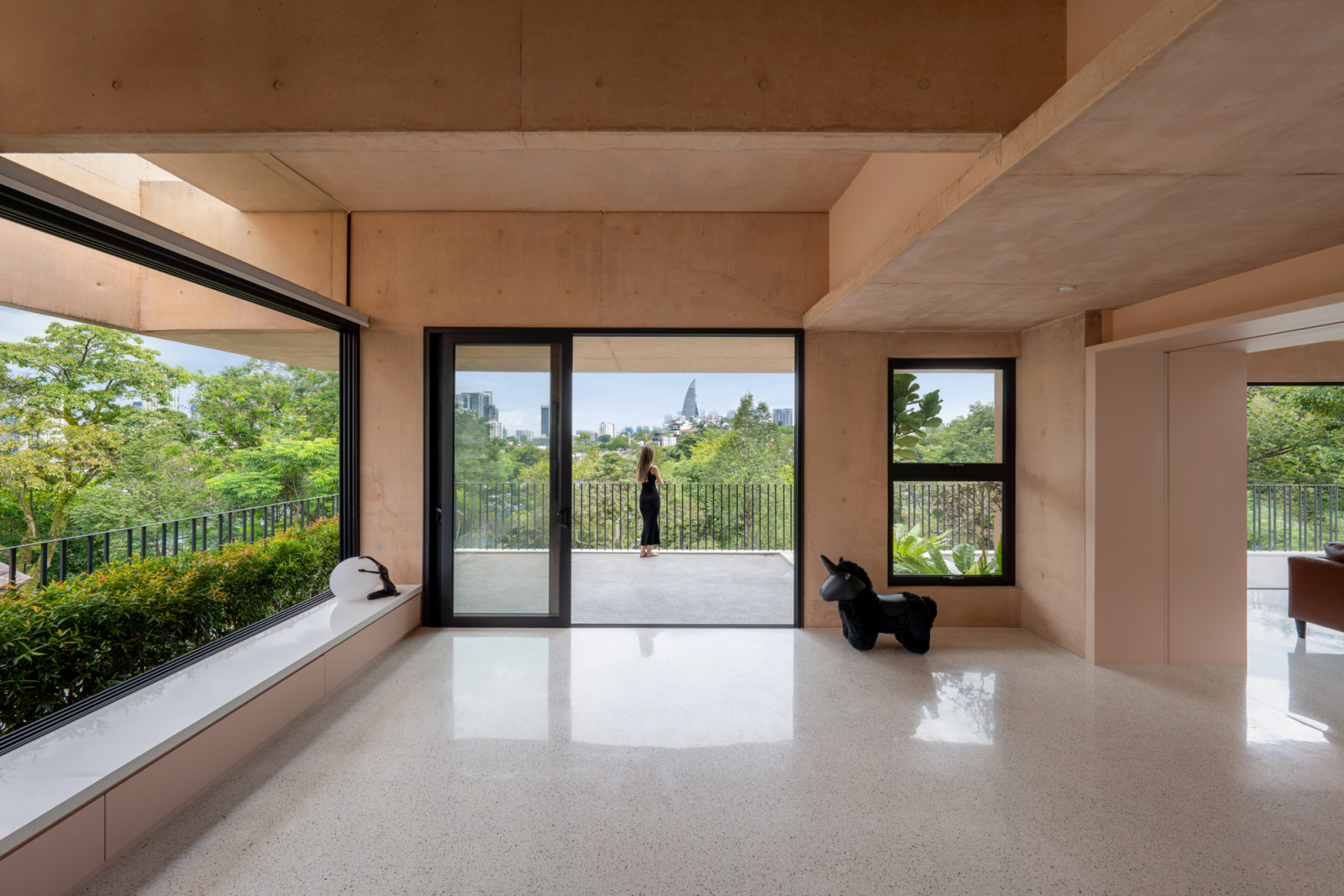 The main living area on the third floor opens onto a balcony with views across the treetops to the Kuala Lumpur skyline