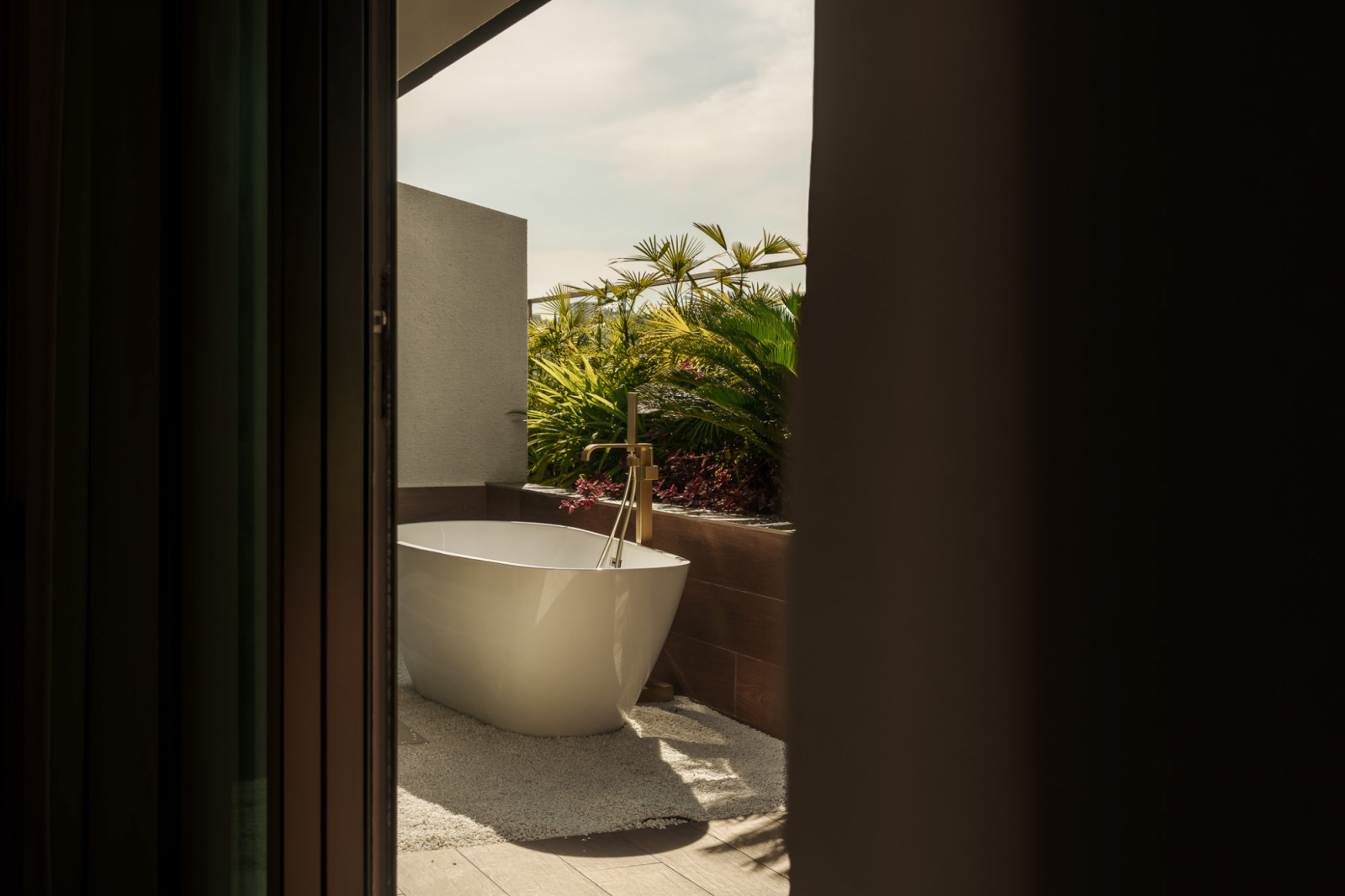 Foliage casts dappled sunlight on the spa-like outdoor bath area