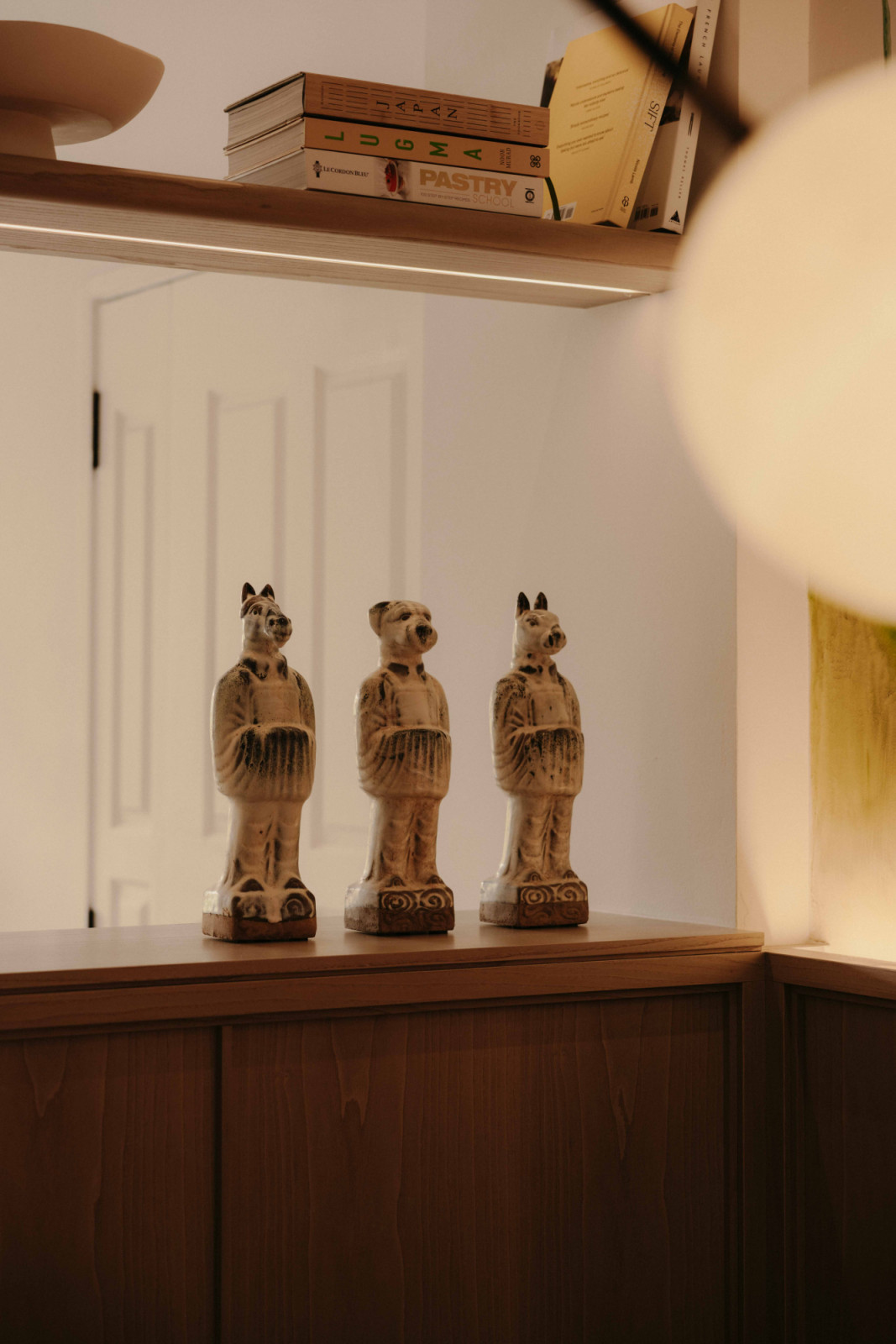 Displayed on the shelf between the entrance and dining area, a trio of Chinese zodiac figurines adds a personal note