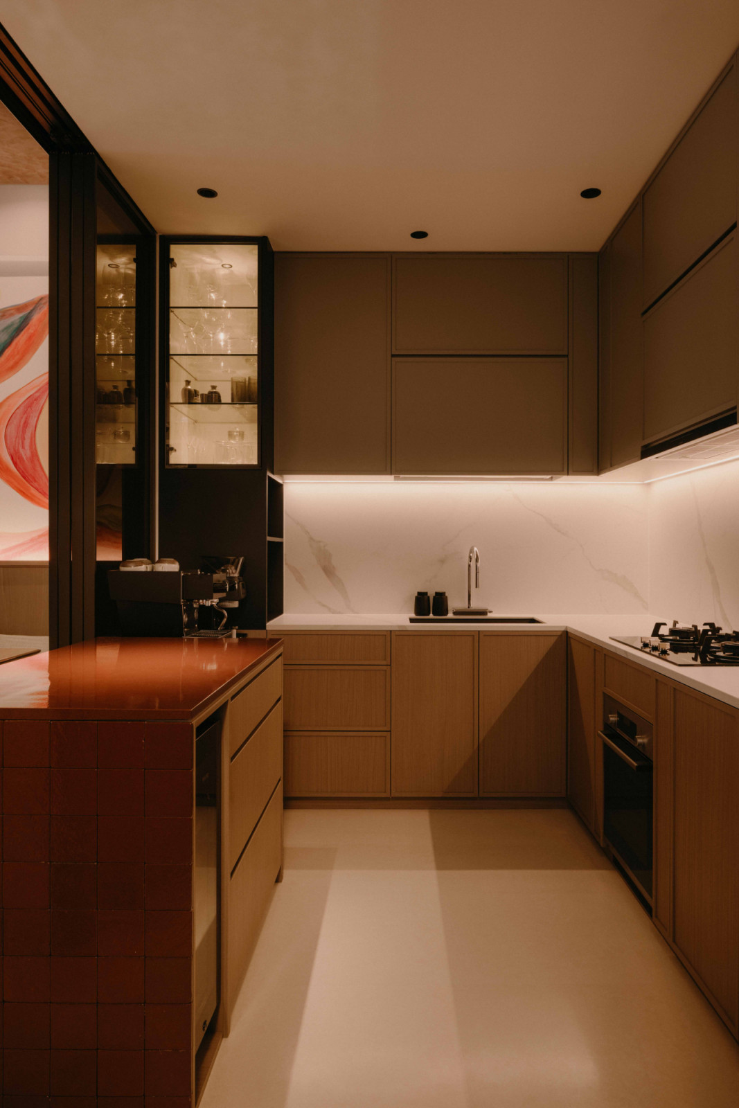 Warm-toned finishes define the kitchen, anchored by a restaurant-grade coffee corner