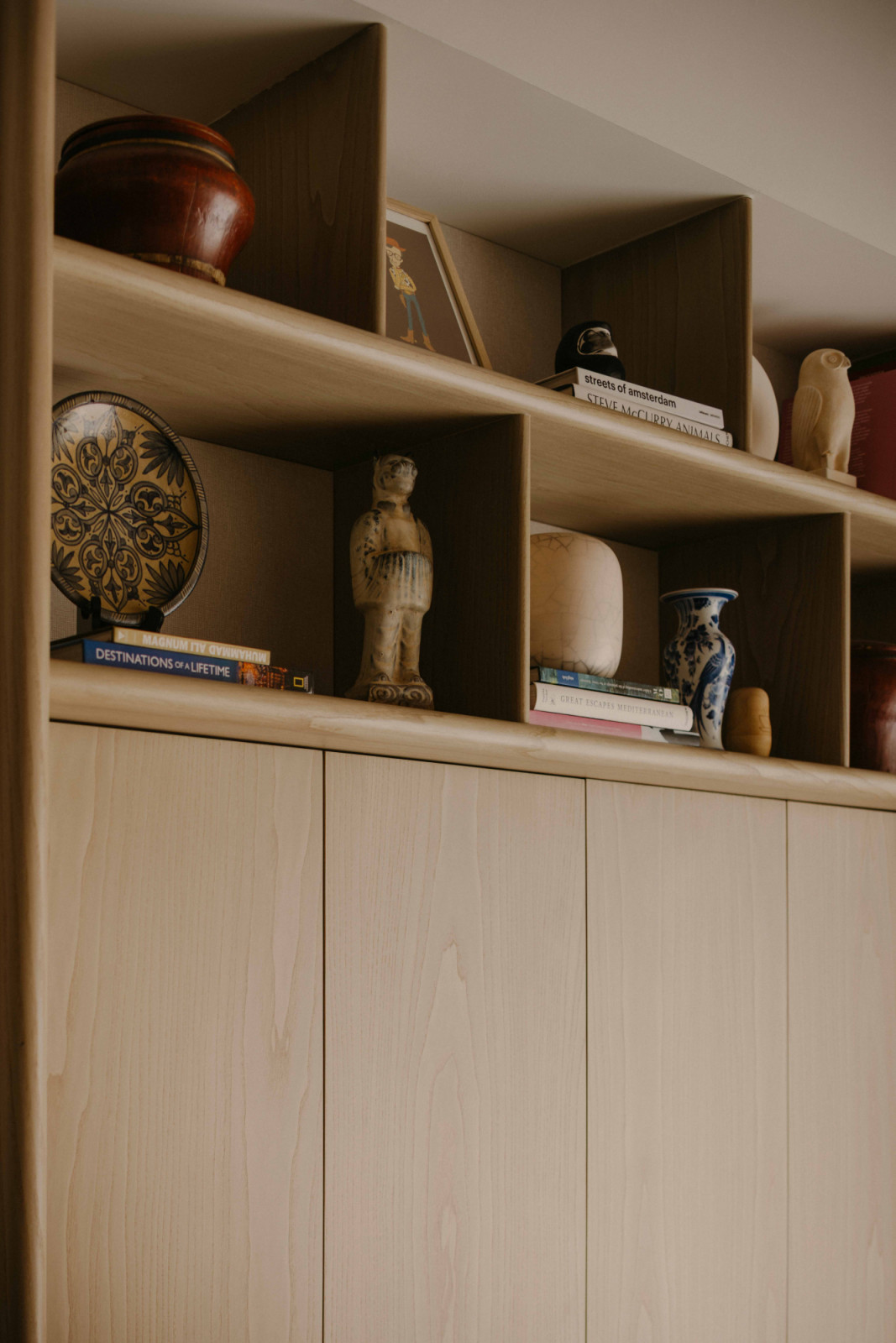 Overhead display shelves display travel finds, keeping everyday storage within easy reach below