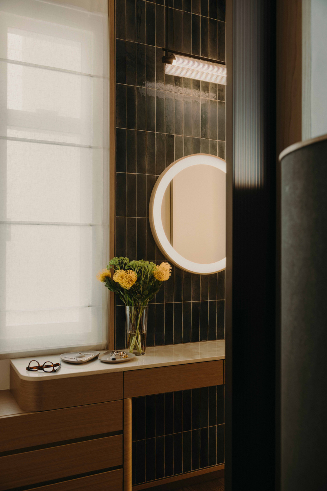 A console in the master bathroom’s lobby serves as a vanity, a place to set things down before and after ablutions
