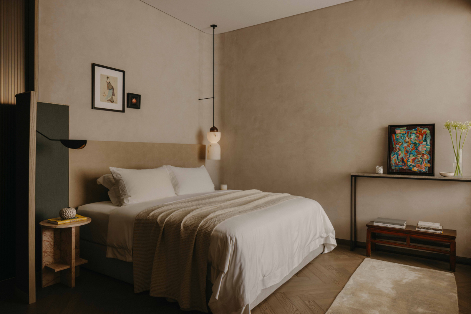 A curved partition beside the bed blocks bathroom light, allowing for an undisturbed night’s sleep