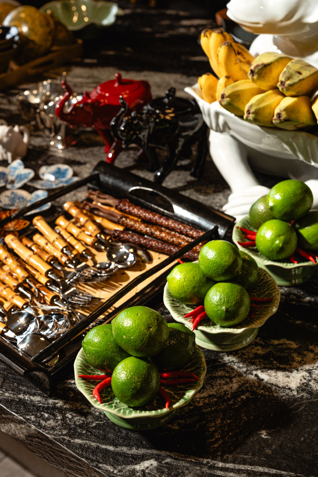 An array of delicious, vibrant fruits and cutlery to be used in Wynn Wynn Ong's tablescapes