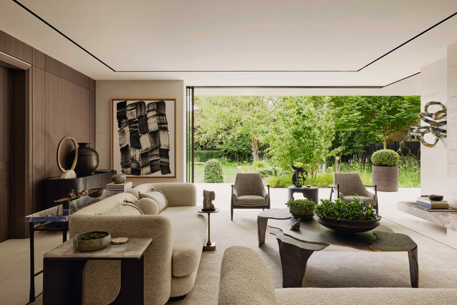 The formal living room with floor-to-ceiling glass doors recessing fully to allow access into and views of the garden