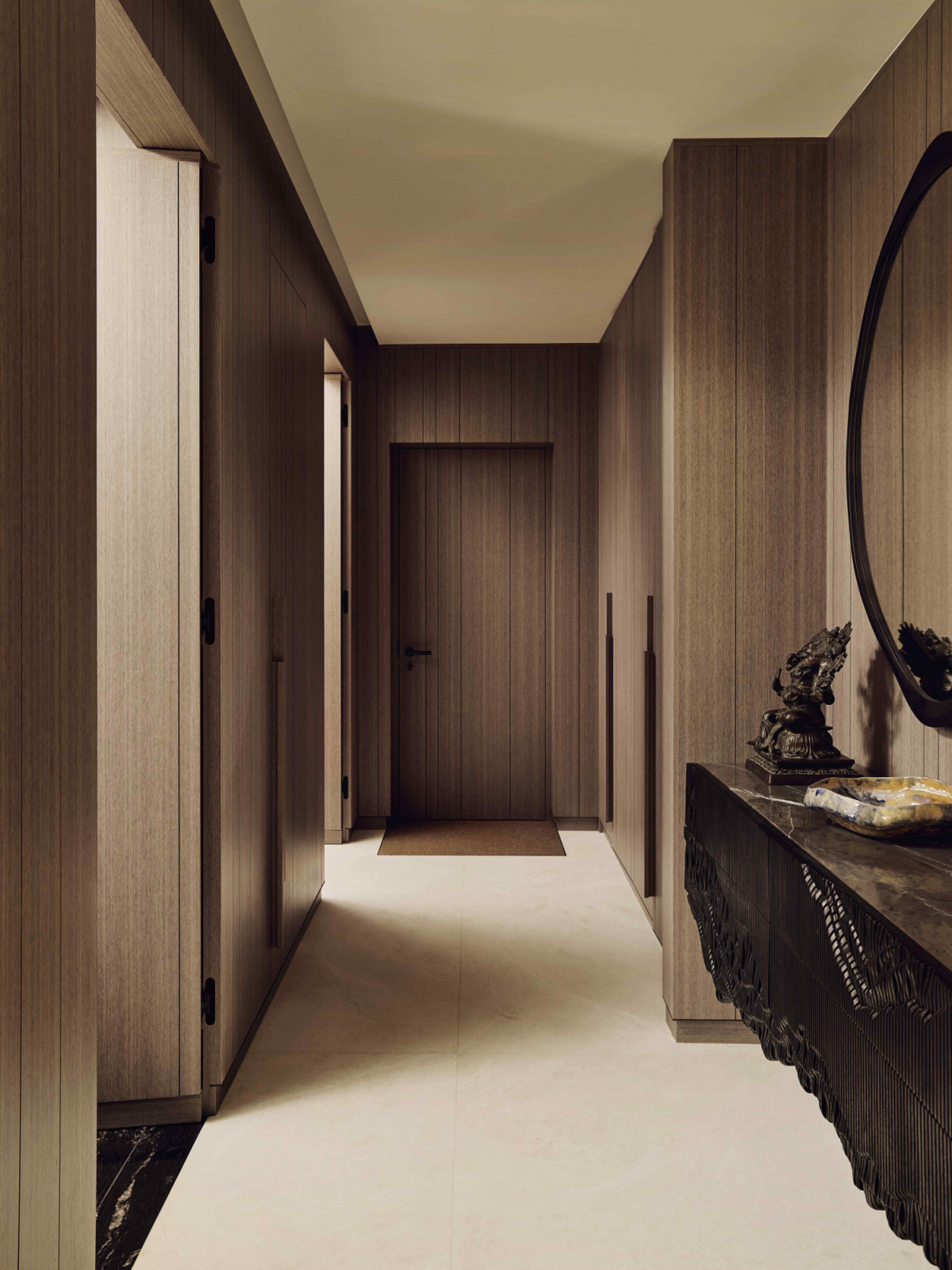 Rich and warm oak finishes on the veneered wall cladding along the hallway to the coat room