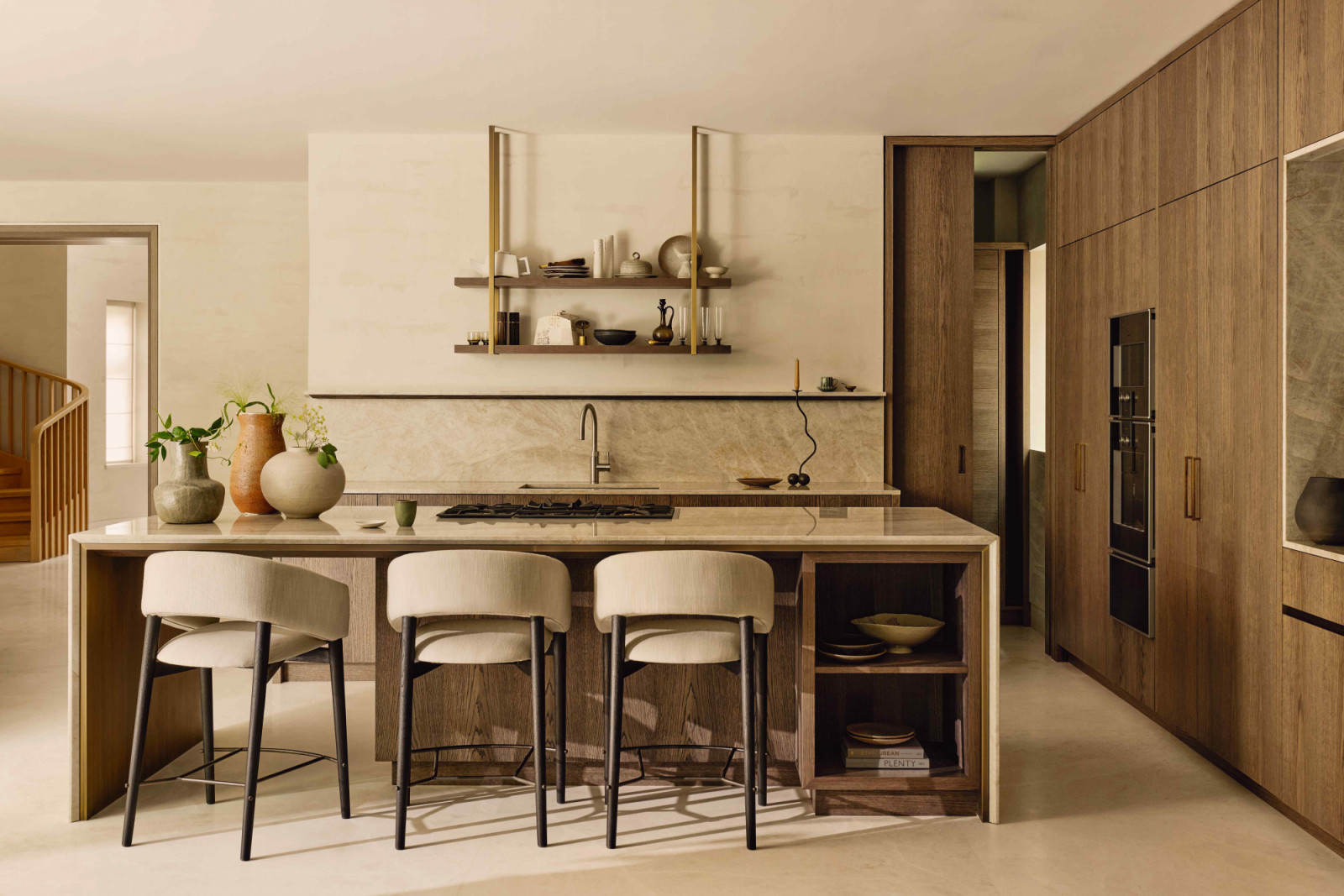 The warm kitchen with a Taj Mahal quartzite worktop and barstools sourced from India