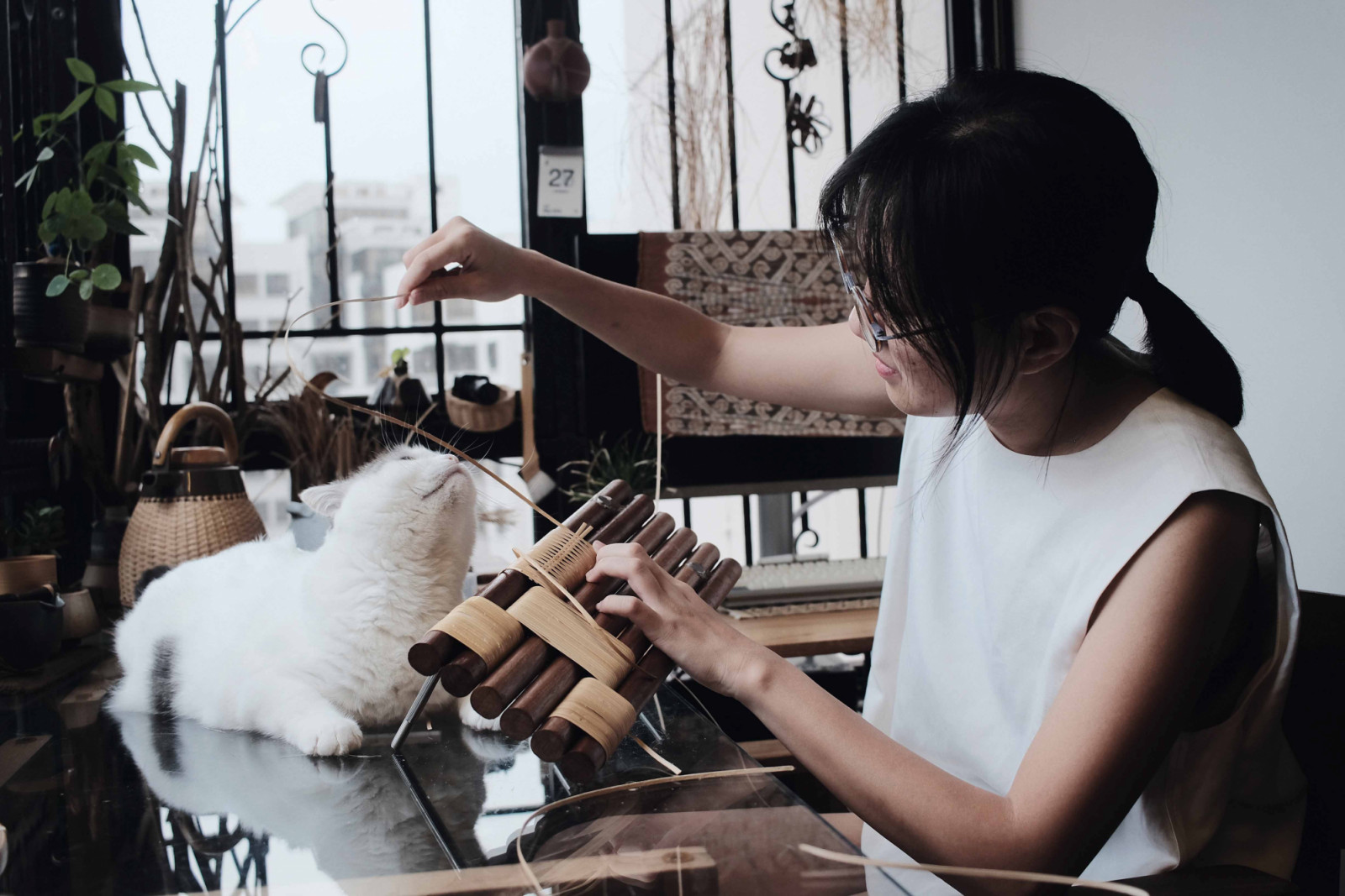 Crafter Ng Si Ying in her workshop with her cat, Ginkgo