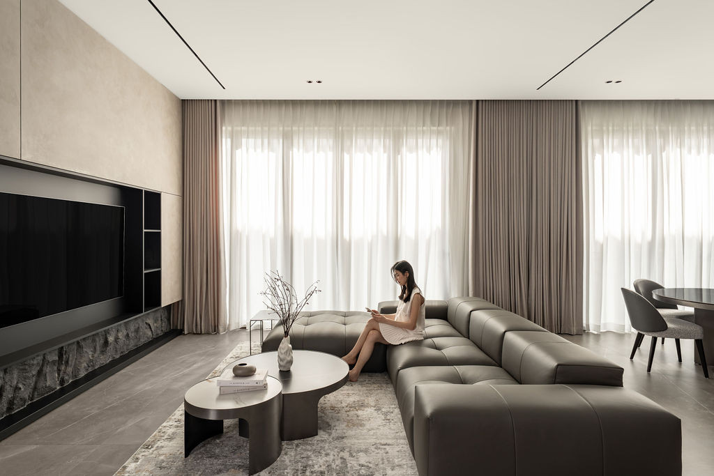 The living area features micro-cement floors and walls, creating seamless surfaces throughout the open-plan space