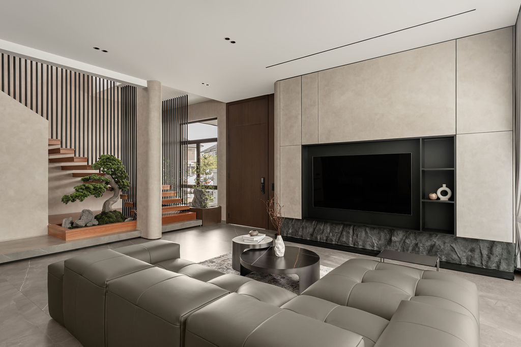 Micro-cement walls and floors unify the living area where a textured stone base anchors the television console