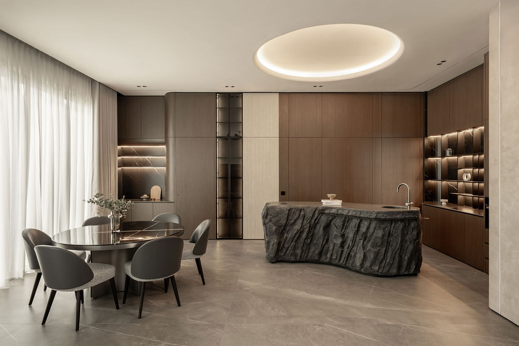 The open-plan dining and kitchen area demonstrates how micro-cement unifies the floor and wall surfaces