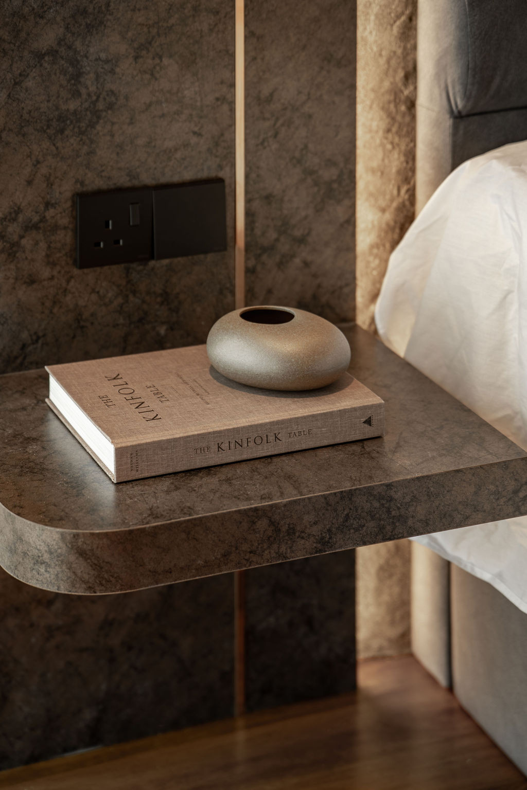 Floating stone bedside tables demonstrate the shadow gap detailing used throughout the home