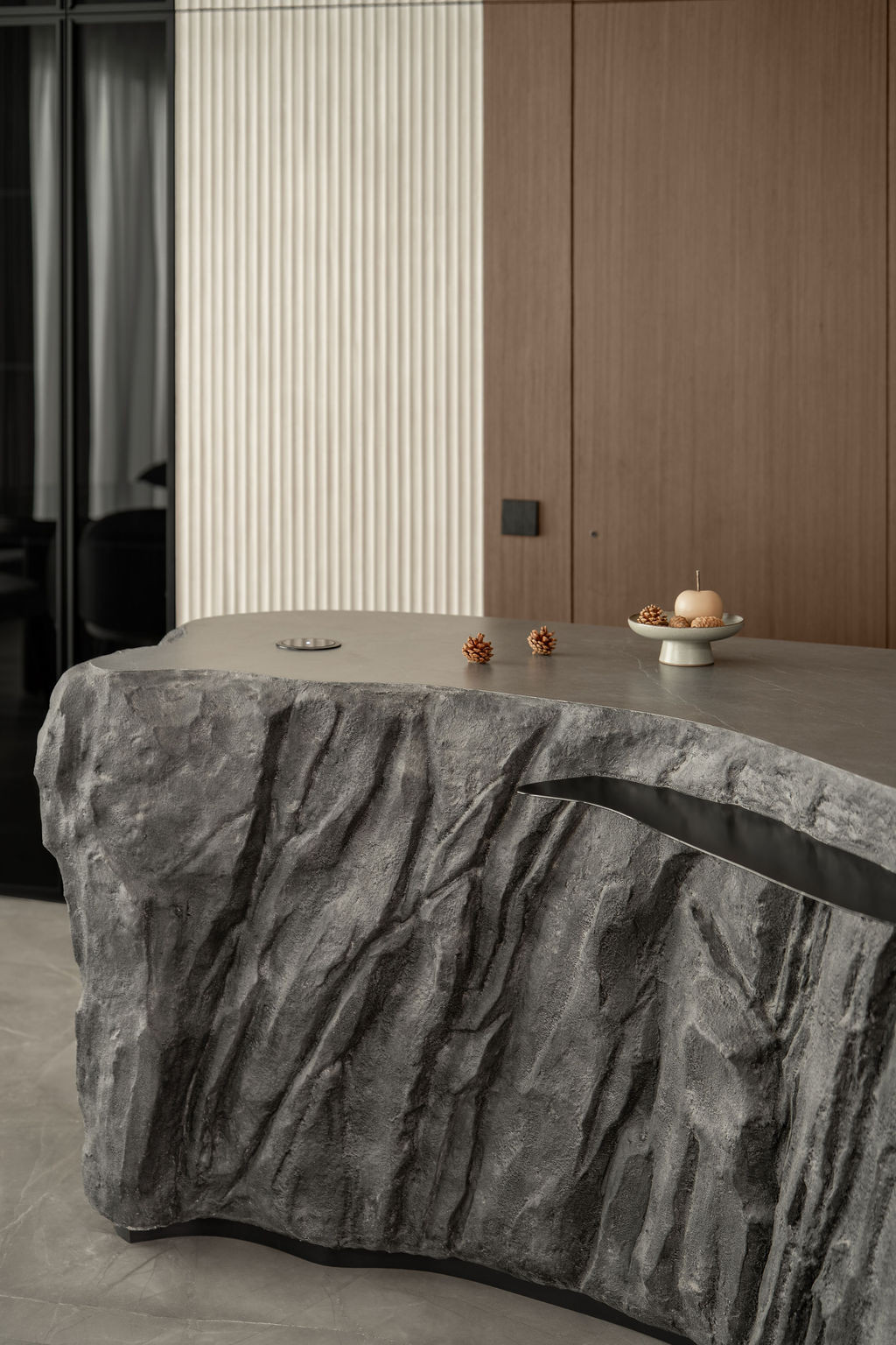Natural light catches the irregular texture of the crafted stone island's hand-worked surface