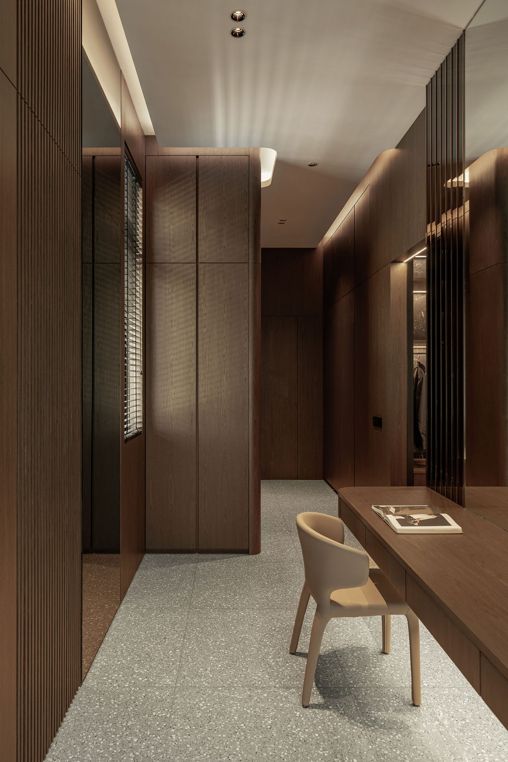 Seamless timber cabinetry in the dressing area features no visible handles and integrated lighting